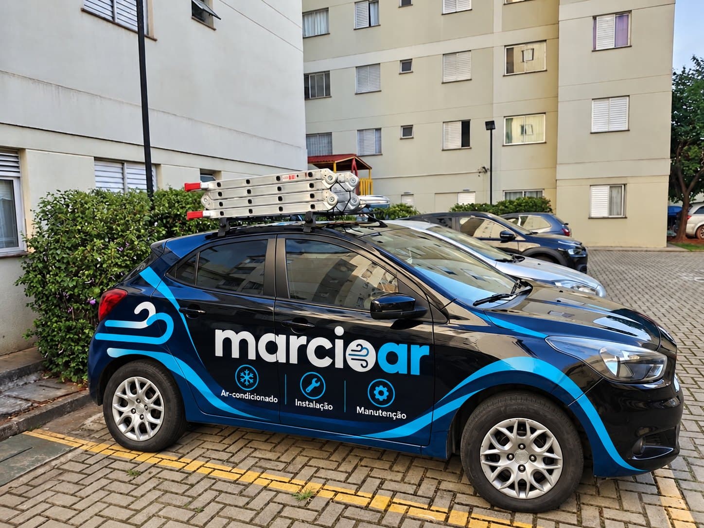 Carro da marcioar adesivado com a marca, com escada no teto, pronto para o atendimento